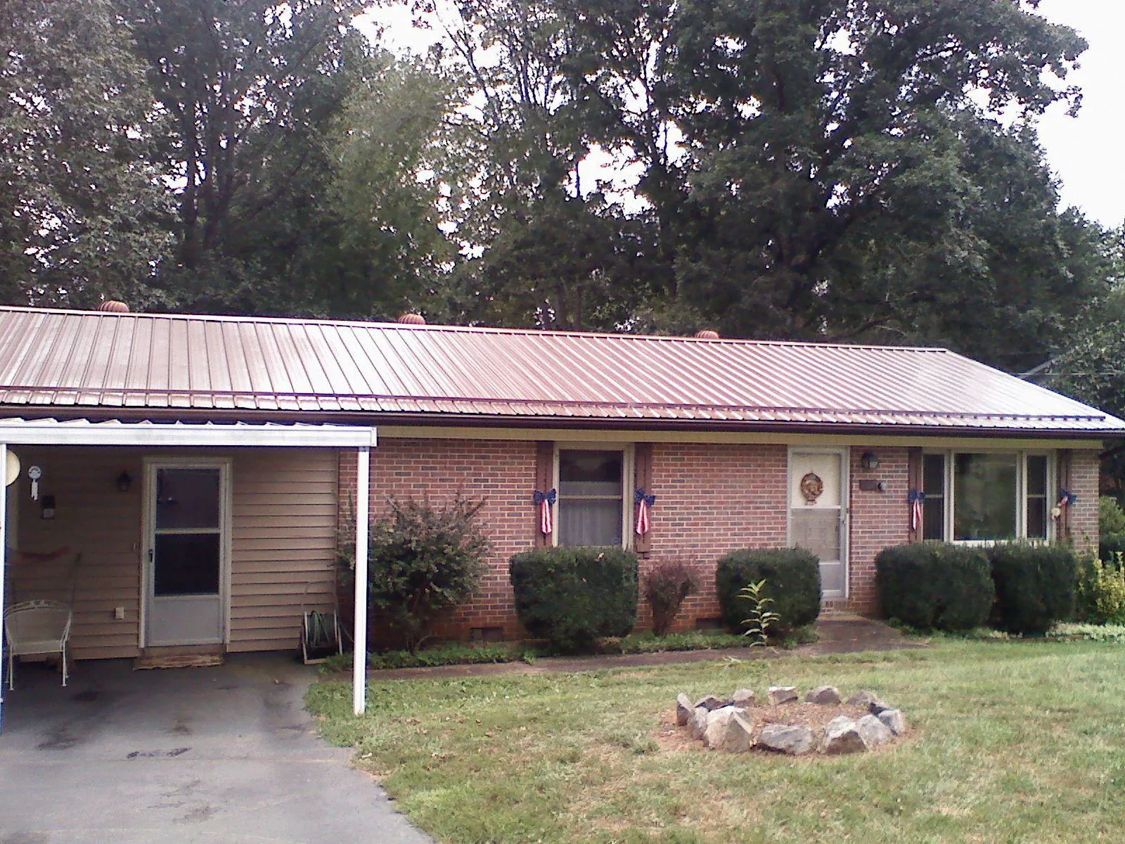 Bronze metal roof and carport on a brick ranch home — Roof Repair work by our crew in Ponchatoula