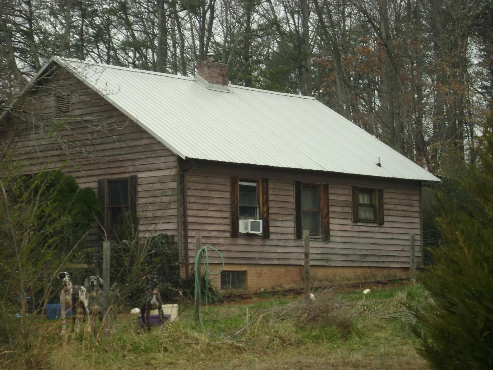 White metal roof on an old wood sided farmhouse, from a Metal Roof Installation job in Ponchatoula
